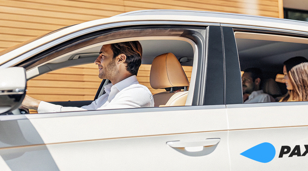 Driver and passengers in car, representing PaxRide's scalable airport transfer solution for business travel.